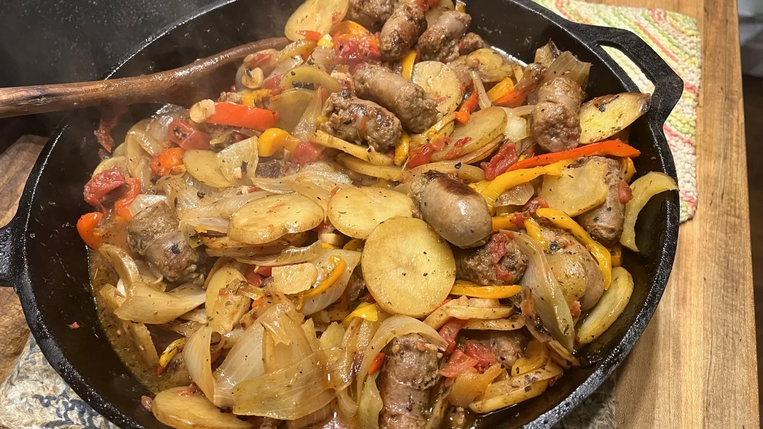 Sausage and peppers with potatoes in a cast-iron skillet